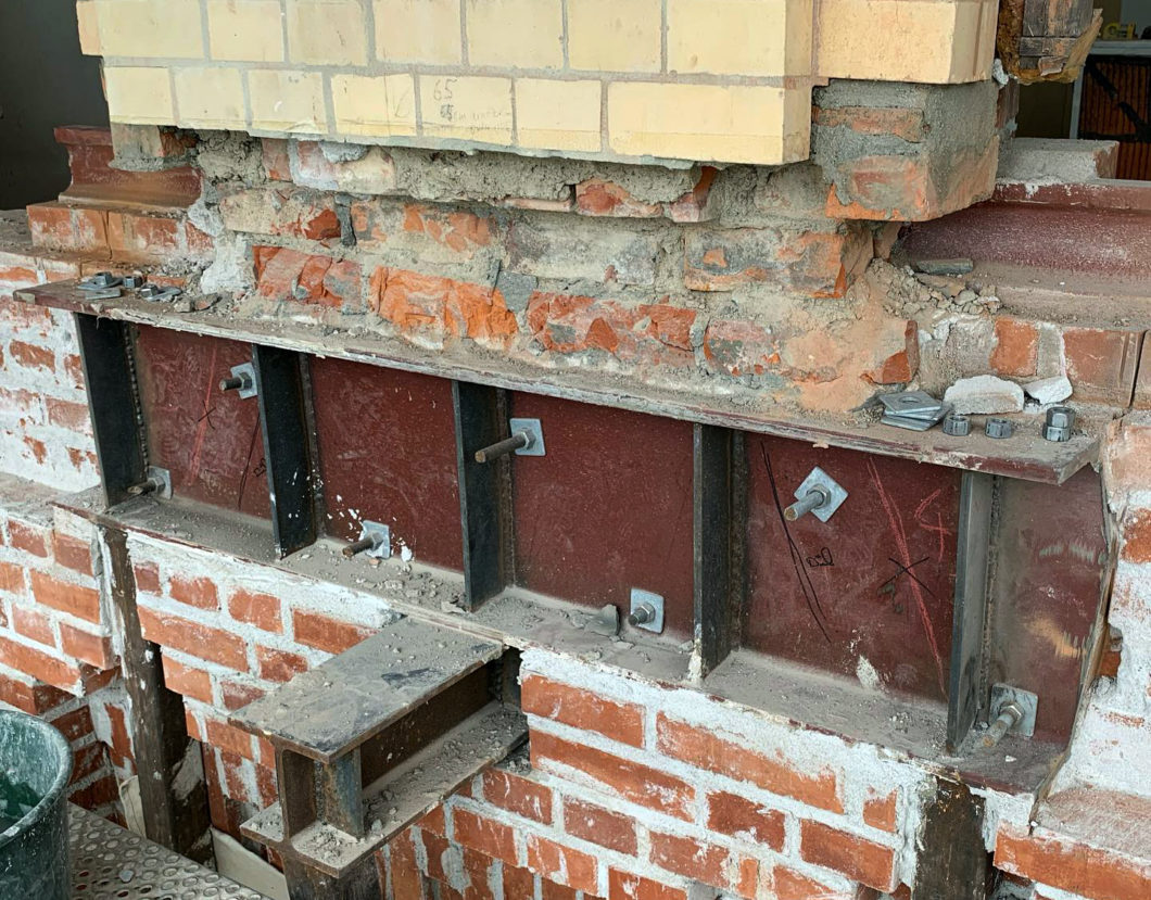 Tillfällig stålkonstruktion under sektion av tegelfasad